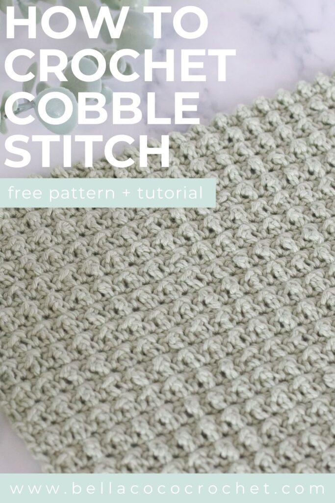Close-up of a crocheted swatch using the cobble stitch in light sage green yarn, displayed on a marble surface with eucalyptus leaves in the background.
