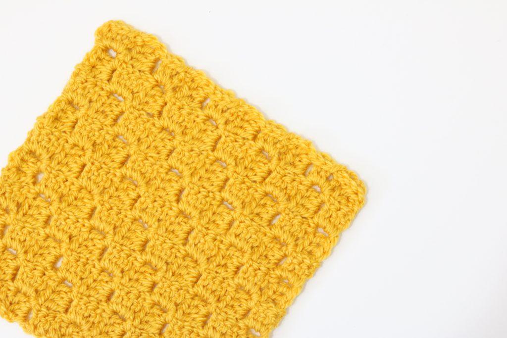 A yellow swatch of Corner to Corner crochet on a white background.