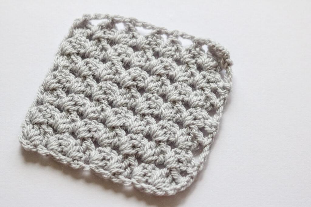 A grey C2C granny square sits on a white background.