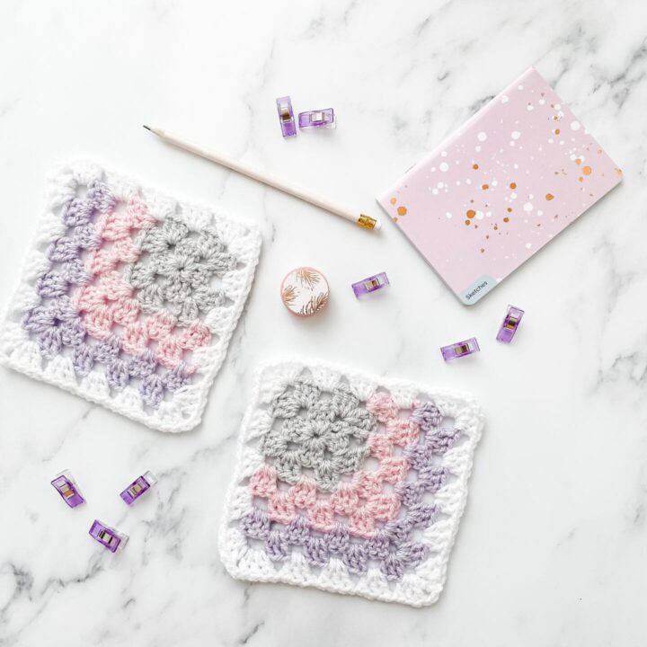 Mitered granny square on a marble background with stationery.