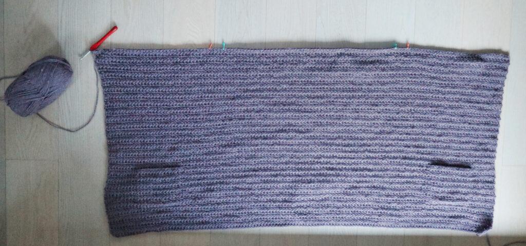A swatch in purple yarn showing the construction of the crochet cardigan