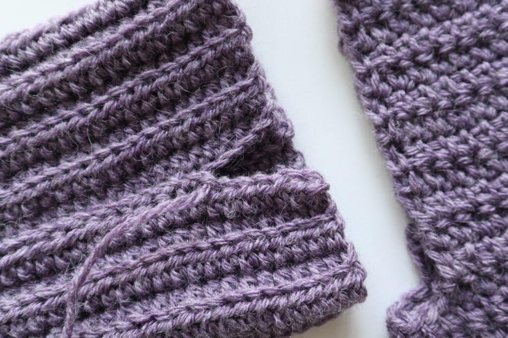 A swatch in purple yarn showing the construction of the crochet cardigan
