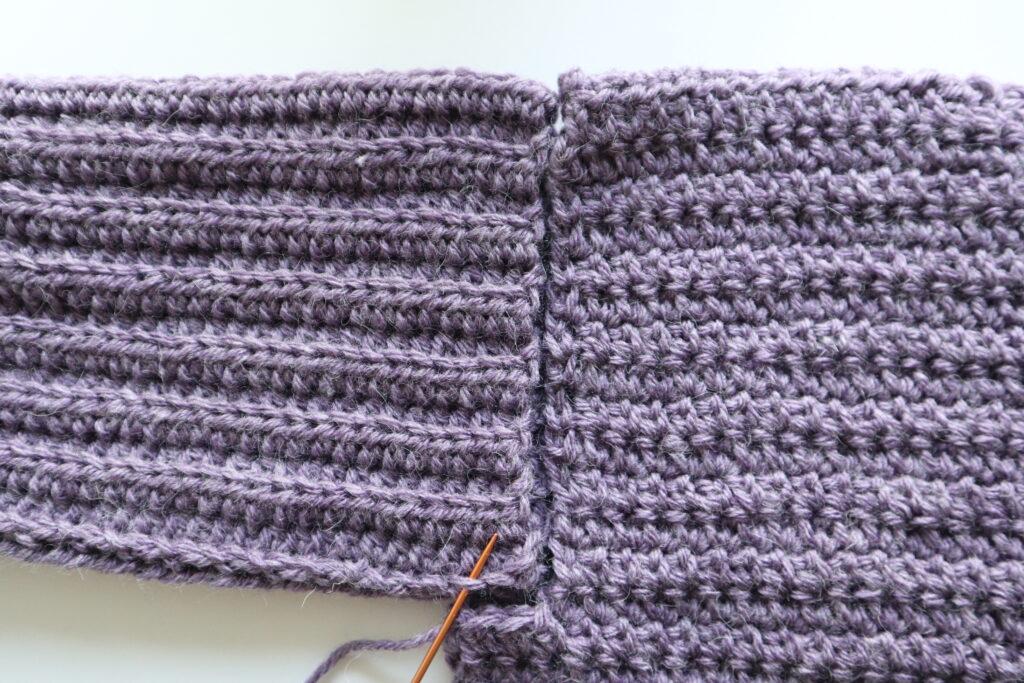 A swatch in purple yarn showing the construction of the crochet cardigan