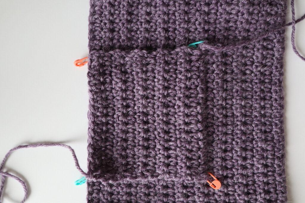 A swatch in purple yarn showing the construction of the crochet cardigan