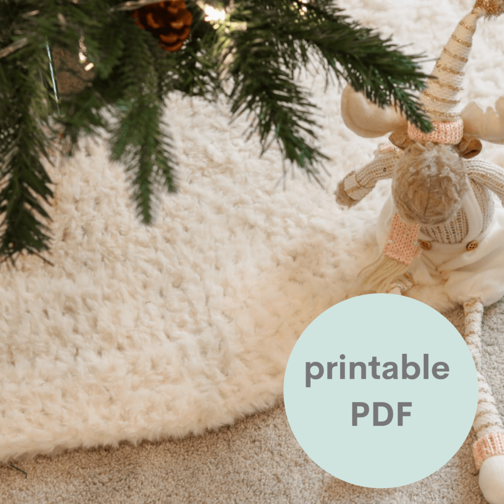 a graphic advertising a PDF showing a crochet tree skirt ade in cream fluffy yarn shown at the base of a Christmas tree with a reindeer teddy sitting on it.