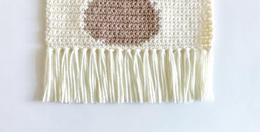 A tutorial graphic showing how to create the fringe for the wall hanging.