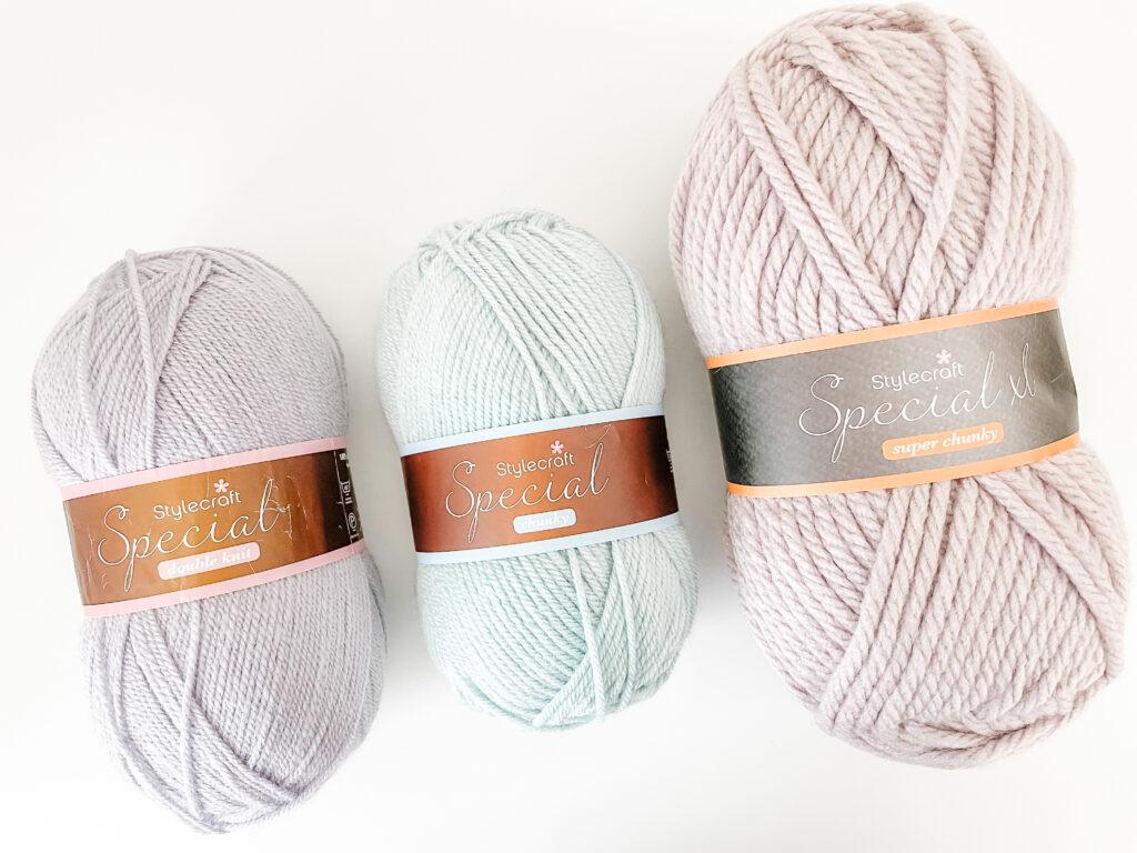 A series of Stylecraft Special yarn balls in DK, Aran and Super Chunky weight. The colours are pale lilac, aqua and biscuit brown.