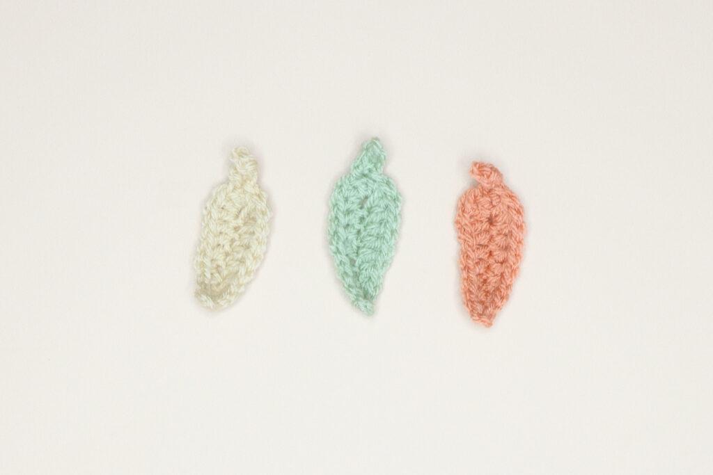 3 crochet leaves in cream, green and orange.