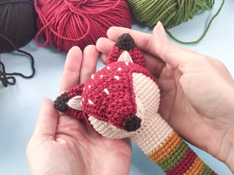 Creator holds Amigurimi Rattle in the shape of a Fox in her hands.