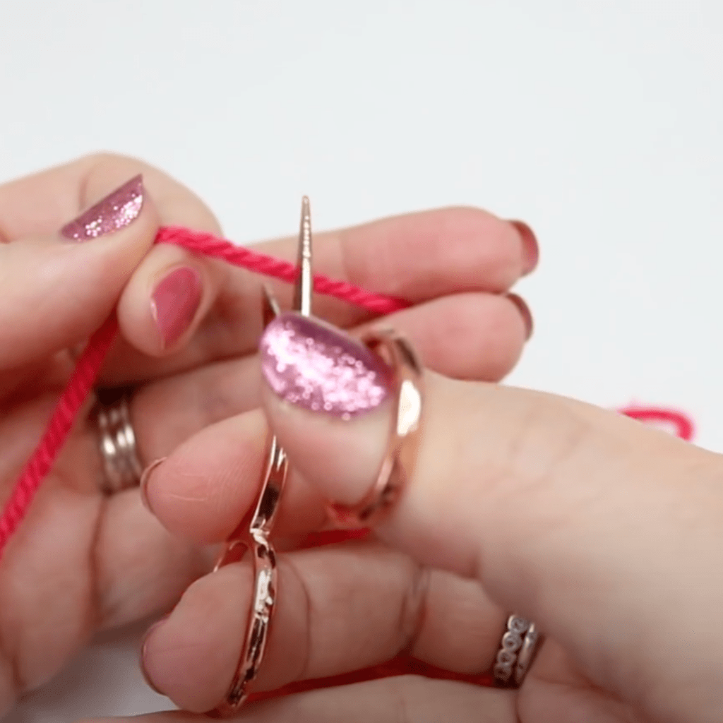 Snipping the yarn at the end of a crochet project.