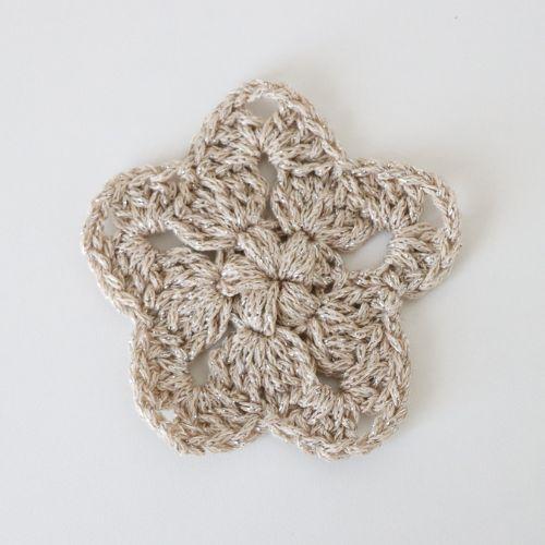 a flat lay image of a crochet star made using a sparkly cotton DK yarn to show how it looks using this yarn and a 4mm hook.