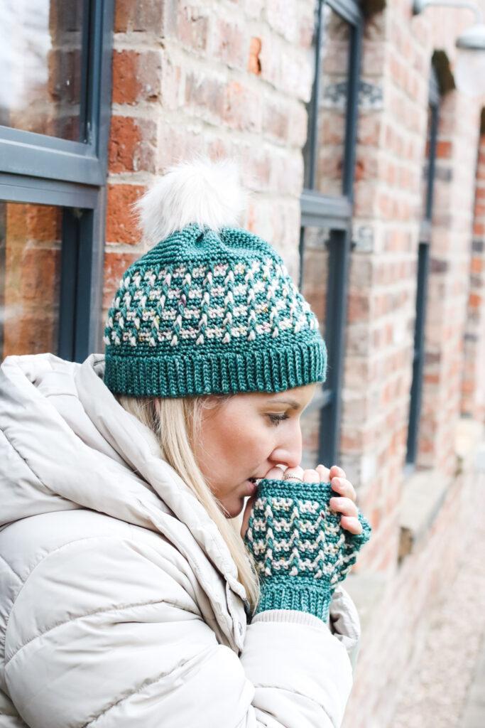 female stood outside wearing a crochet beanie hat in red and cream indie-dyed yarn.