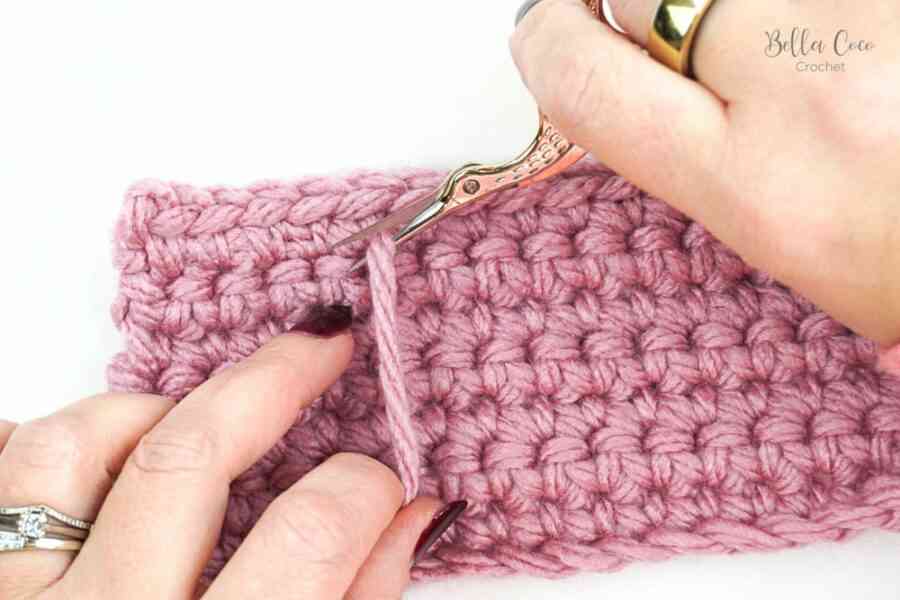 snipping off yarn with gold scissors