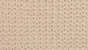 Close-up of a beige crochet swatch using the V-stitch, showing a lacy and open texture with a repeating V-shaped pattern.